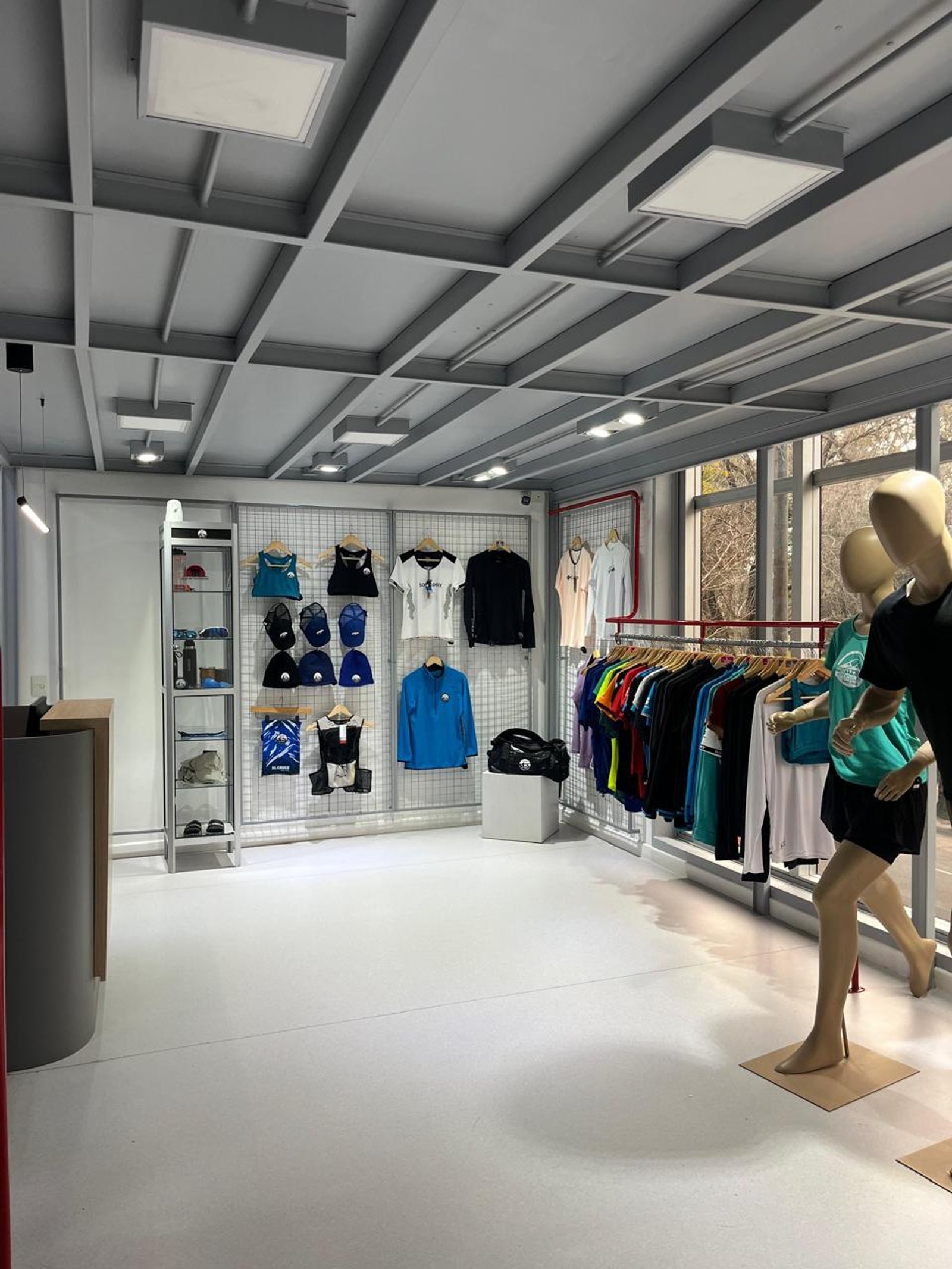 Loja de roupas com teto industrial, paredes metálicas e piso de microcimento branco — projeto Oficinas CDC, por cromo., em Belgrano